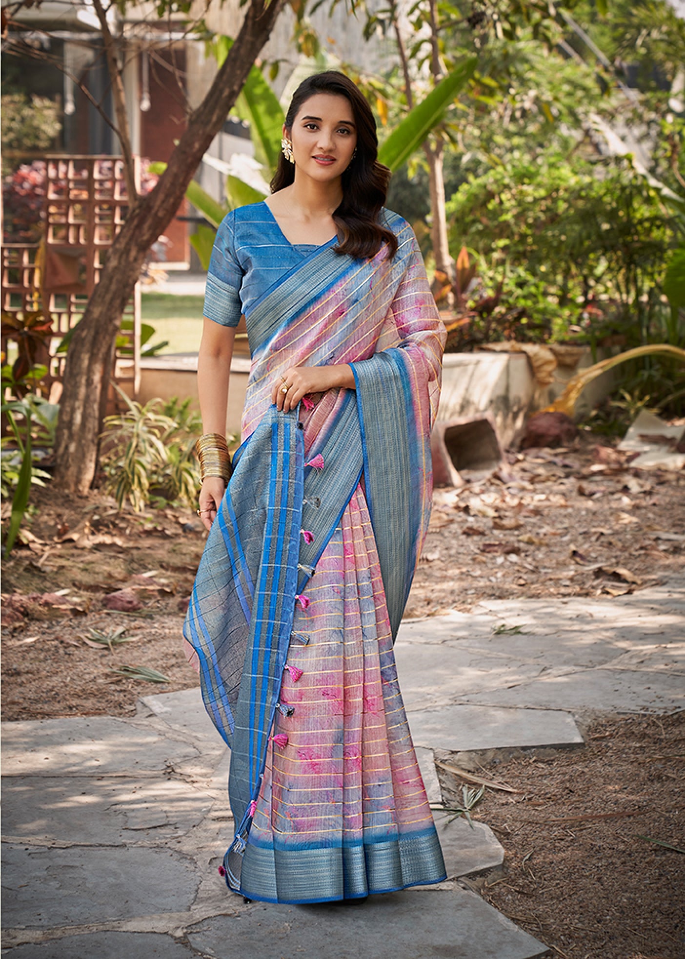 Steel blue watercolor linen saree with pink pattern and gold check border, draped on model