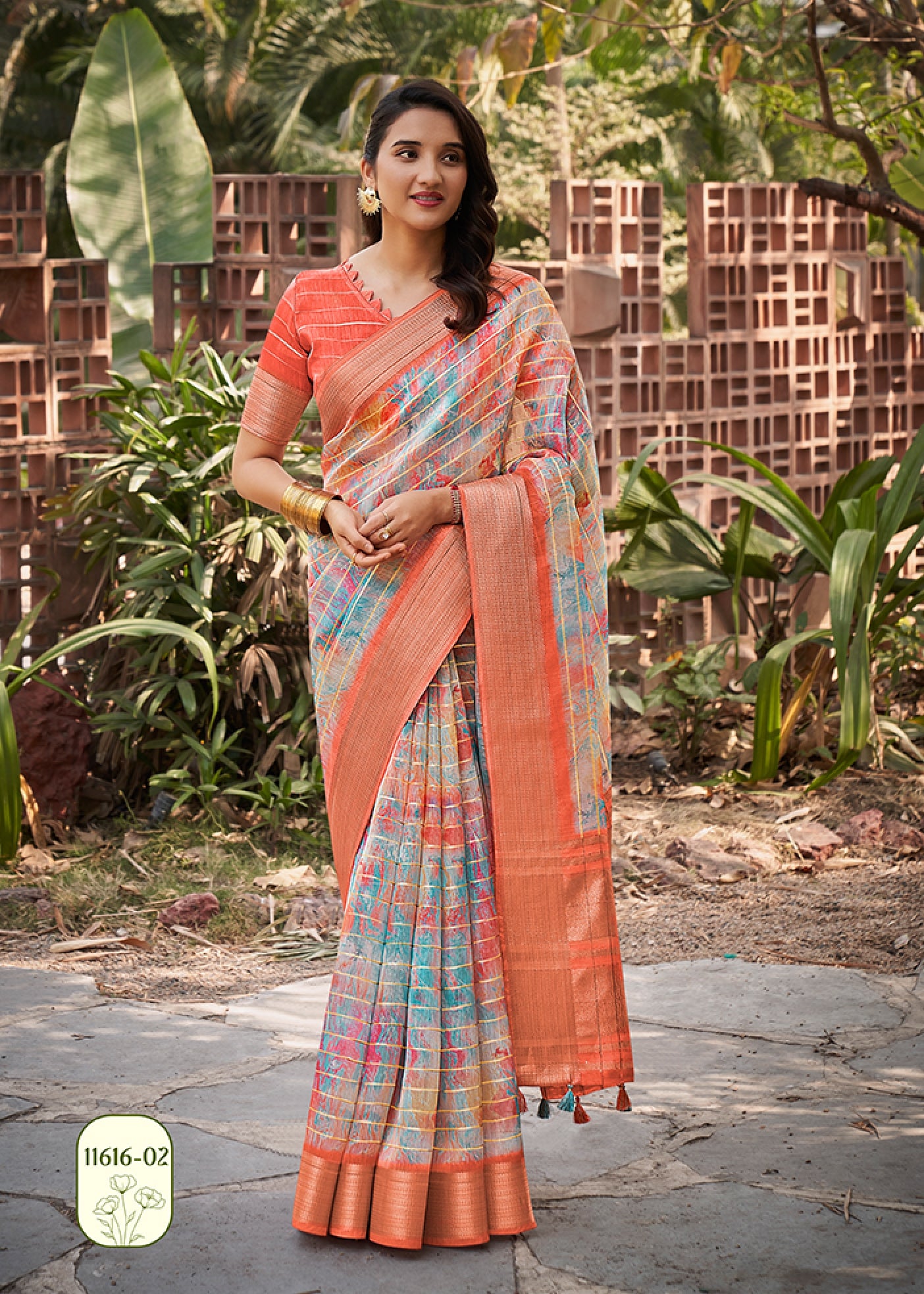 Coral orange watercolor linen saree with teal-pink pattern and gold check border, draped