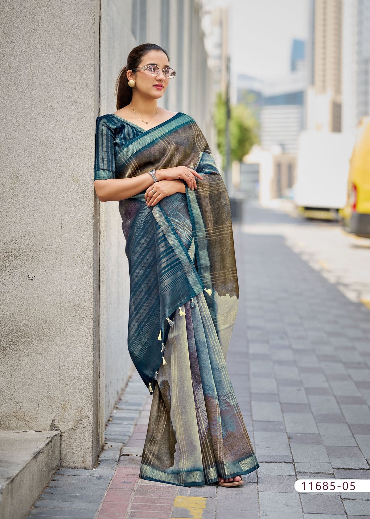 Cotton fancy saree in teal blue with beige accents and bordered pallu.