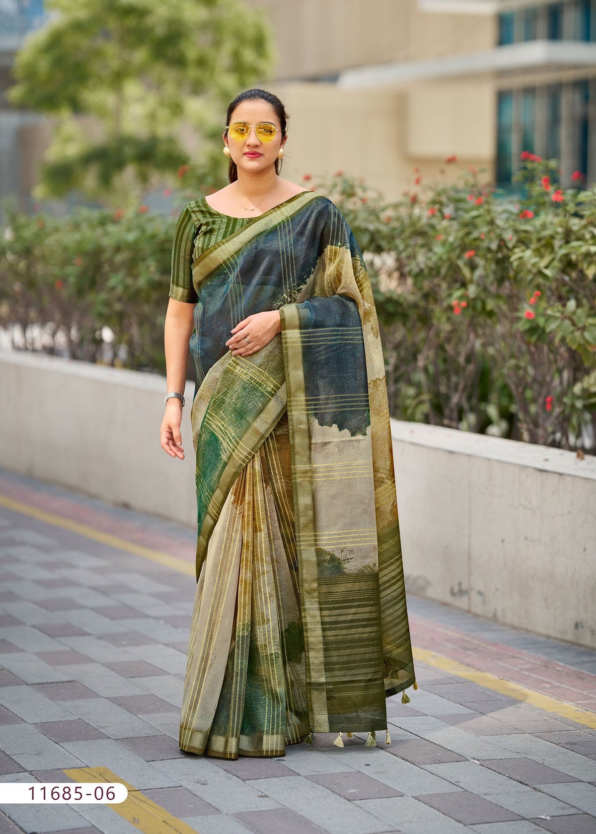 Cotton fancy saree in olive green with gold stripes and bordered pallu.