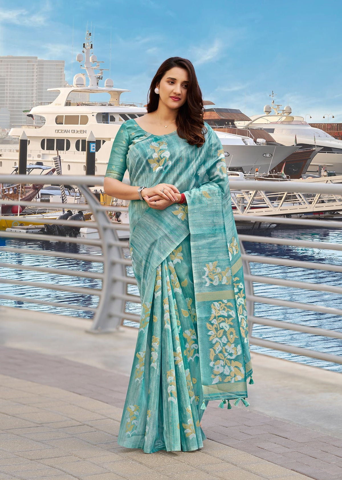Teal blue cotton saree with gold motif border and draped pallu