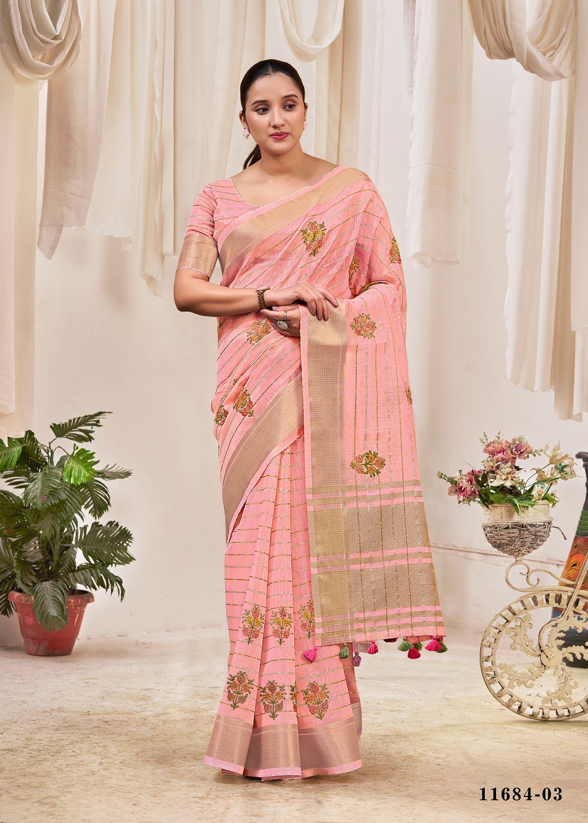 Pink cotton saree with floral print, striped border, and matching pallu