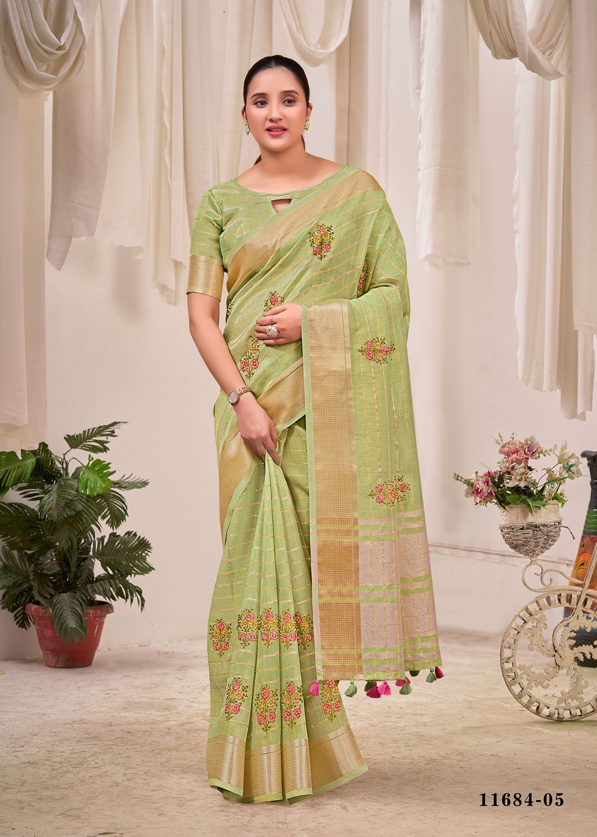Light green cotton saree with floral print, check-style border, and matching pallu