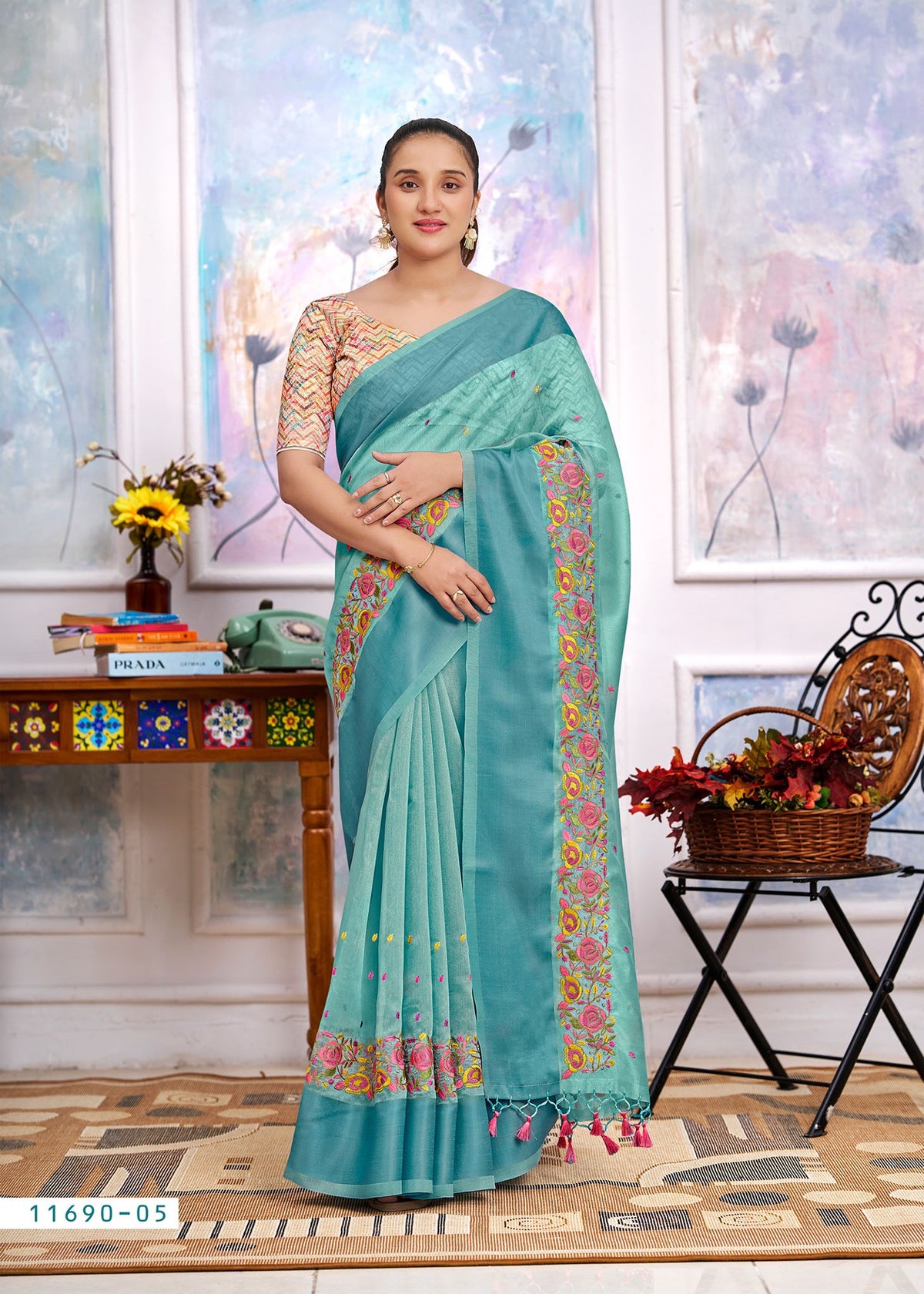 Aqua blue cotton saree with floral border, embroidered pallu drape and tassel ends
