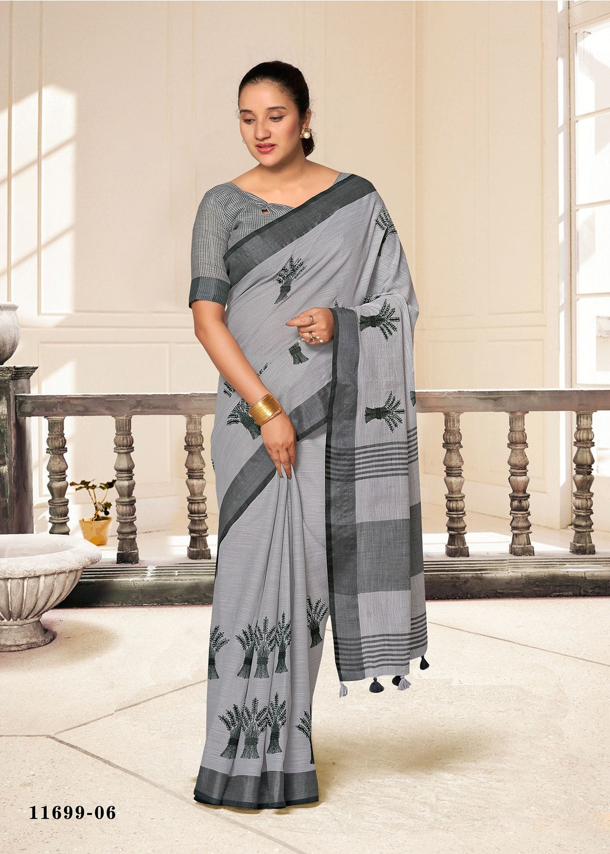 Cotton fancy saree in light gray with dark leaf motifs and gray border stripe.