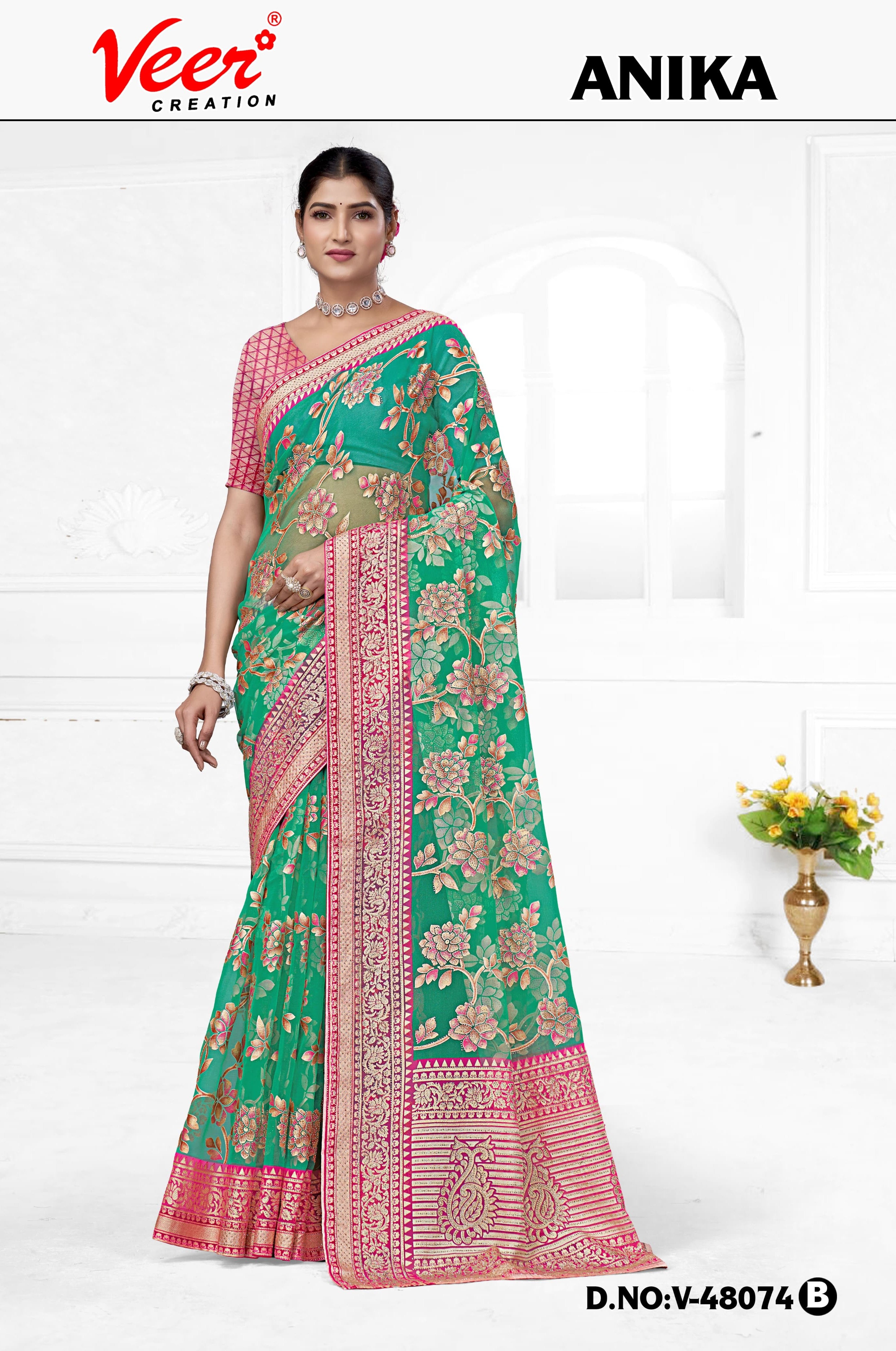 Teal-green floral net saree with zari border and patterned pallu