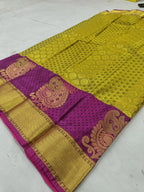 Olive-gold silk saree with purple border and paisley-style motifs, flat lay