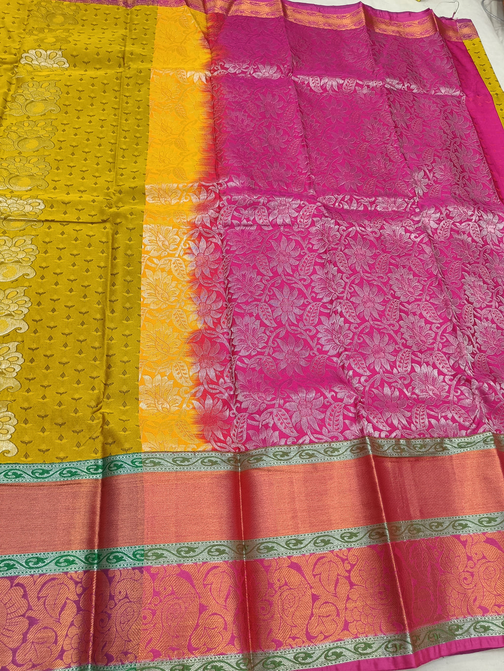 Yellow and pink Kanchipuram silk saree with green border and ornate woven motifs