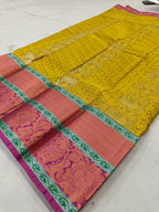 Yellow Kanchipuram silk saree with pink yoke, green border, patterned fabric