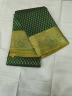 Folded dark green saree with dotted geometric pattern and gold zari border