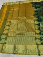 Gold-patterned saree pallu with zari motifs and border on dark green base