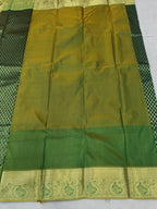 Pleated dark green and gold saree with wide zari border at the hem