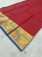 Red silk saree fabric with gold-and-blue border and ornate medallion band