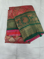 Draped pink saree with green-gold border, ornate motifs, and contrasting blouse panel