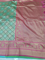 Banarasi silk saree close-up: teal pattern, pink panel, magenta border, gold motifs