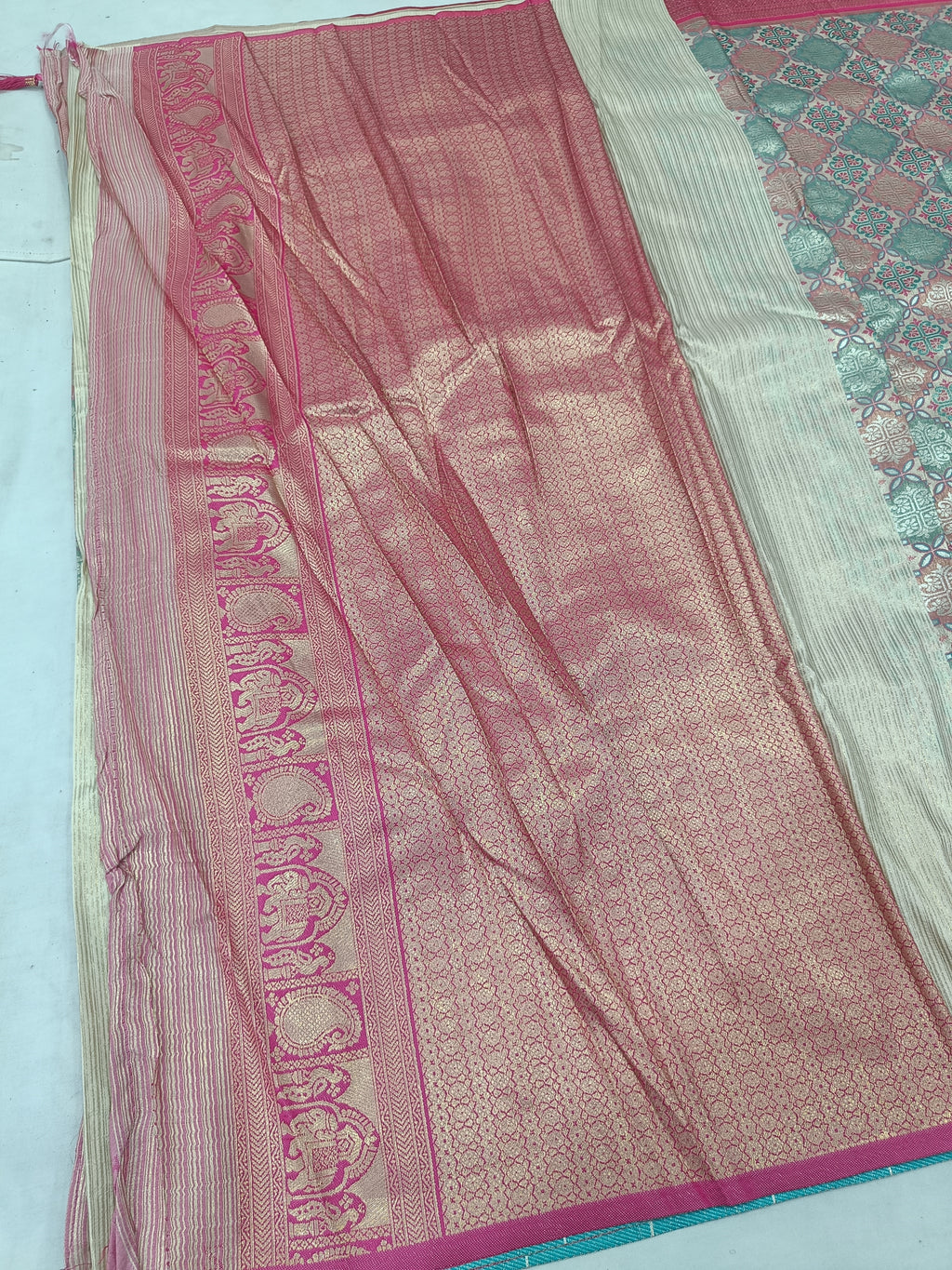 Multicolor silk saree with pink panel, teal selvedge, decorative motifs, tassels on edge
