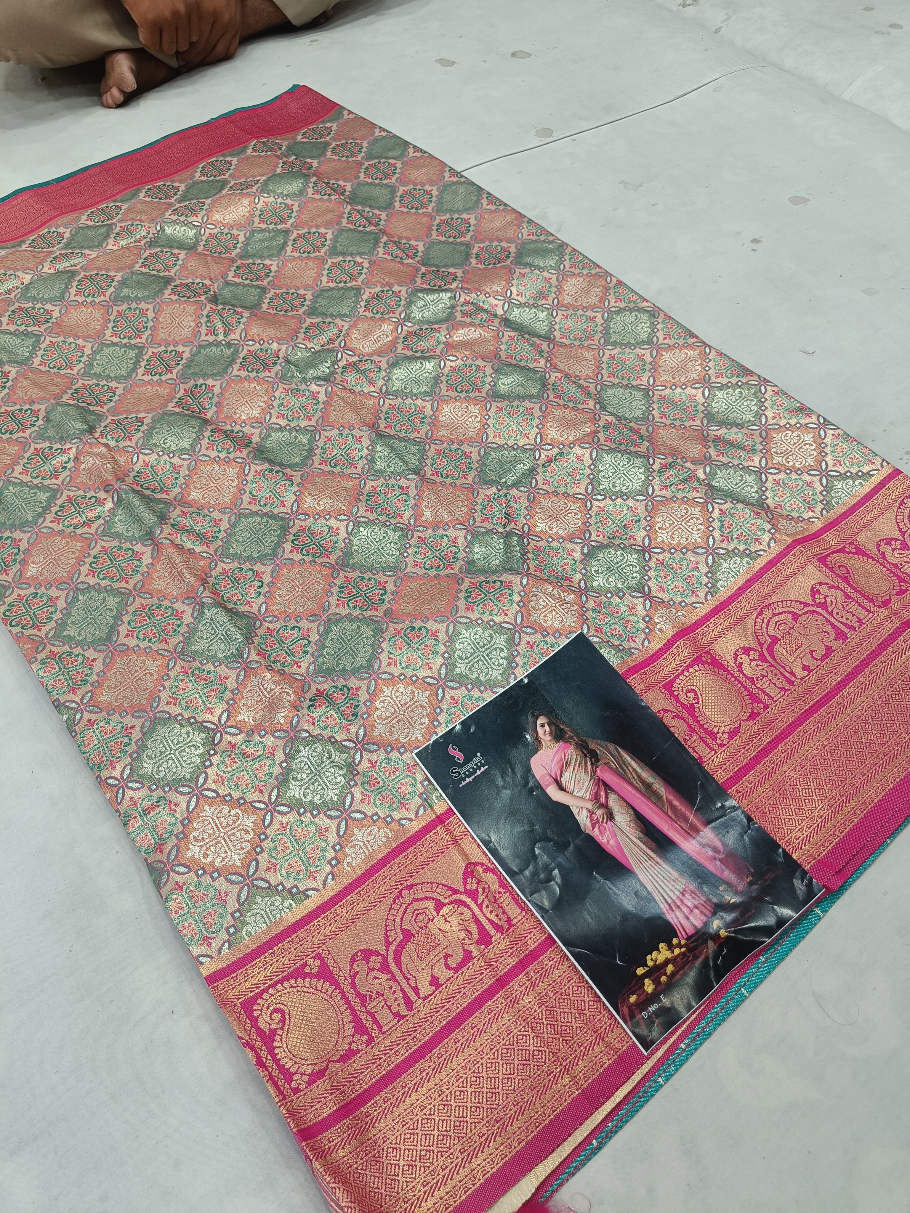 Multicolor silk saree laid flat, geometric motifs and wide magenta zari border