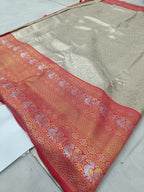 Silver silk saree pallu with red ornate motifs and border, folded on sheet