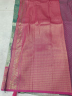 Teal green and magenta pink Banarasi silk saree with wide border and textured pattern