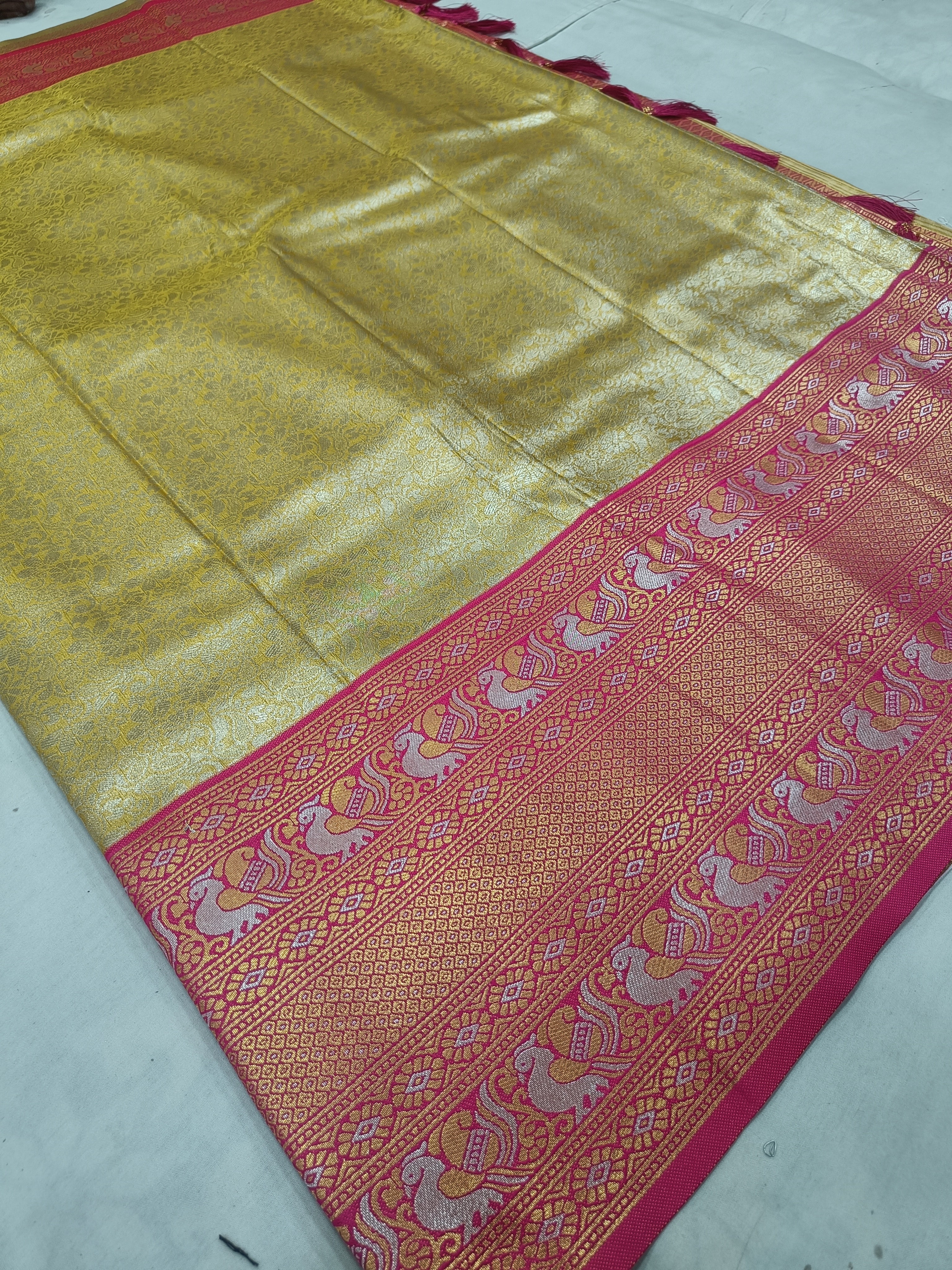 Gold Banarasi silk saree with pink patterned border and detailed woven stripe