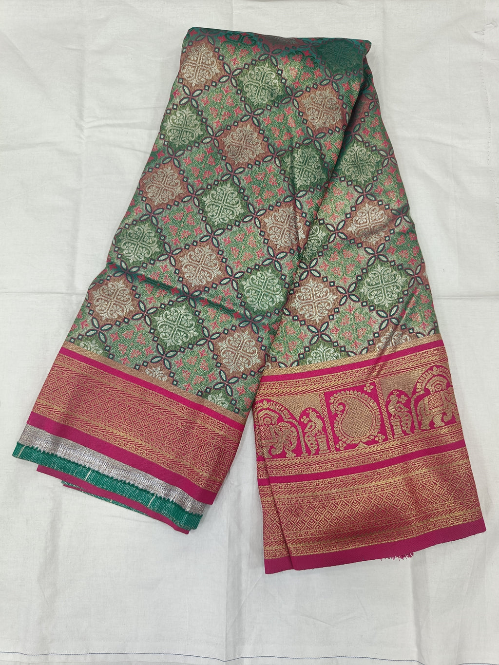 Teal green and pink Banarasi silk saree fabric with geometric motifs and gold border