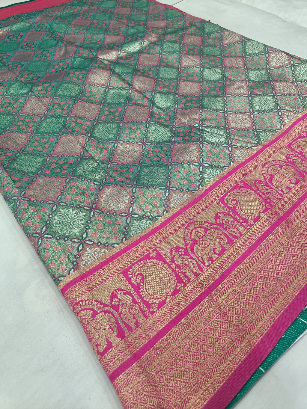 Teal green Banarasi silk saree with pink patterned border and woven lattice motifs