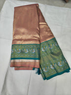 Folded peach silk saree with wide aqua blue border and gold woven motifs