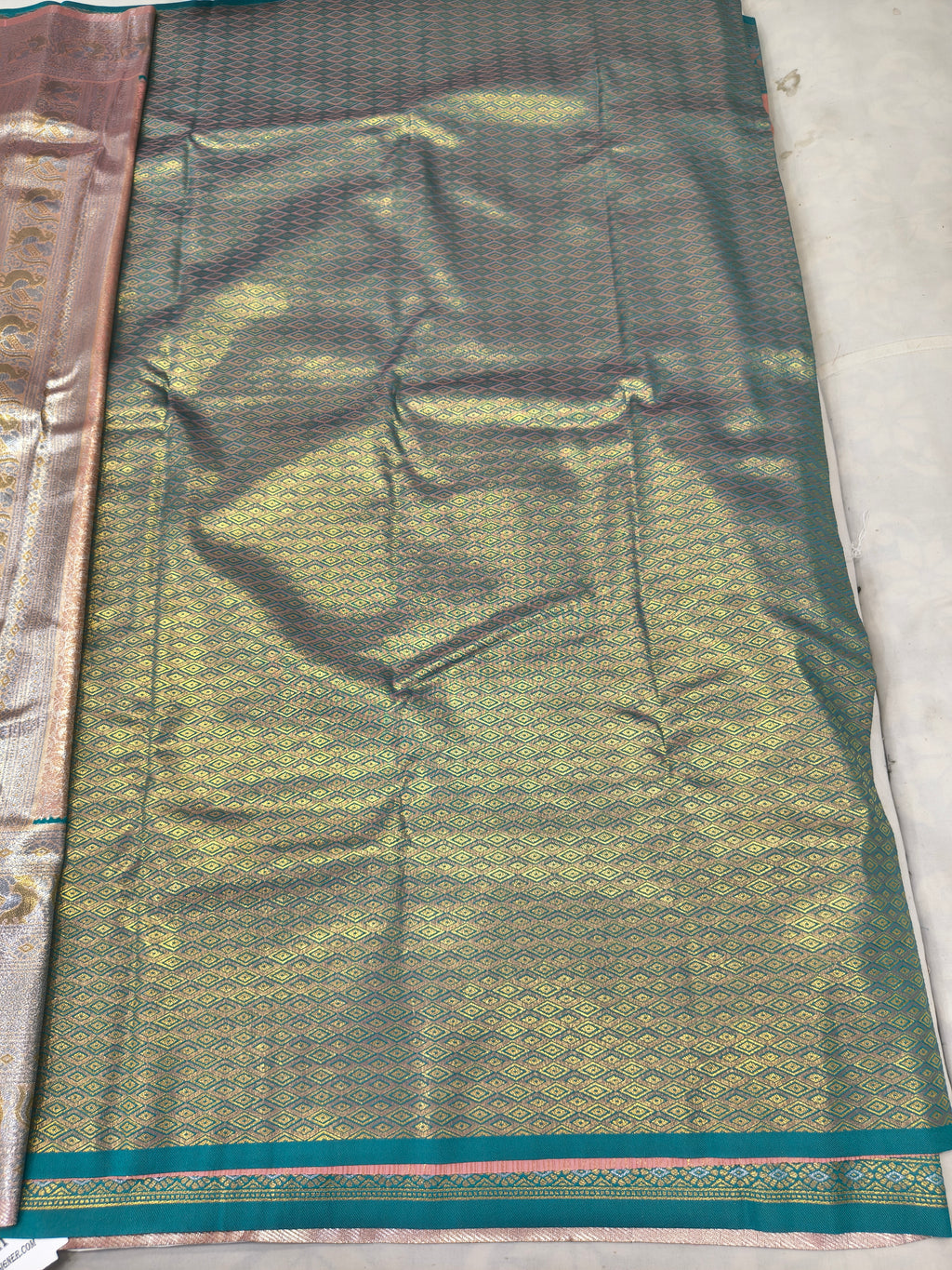 Aqua blue and gold patterned silk saree section with decorative border trim