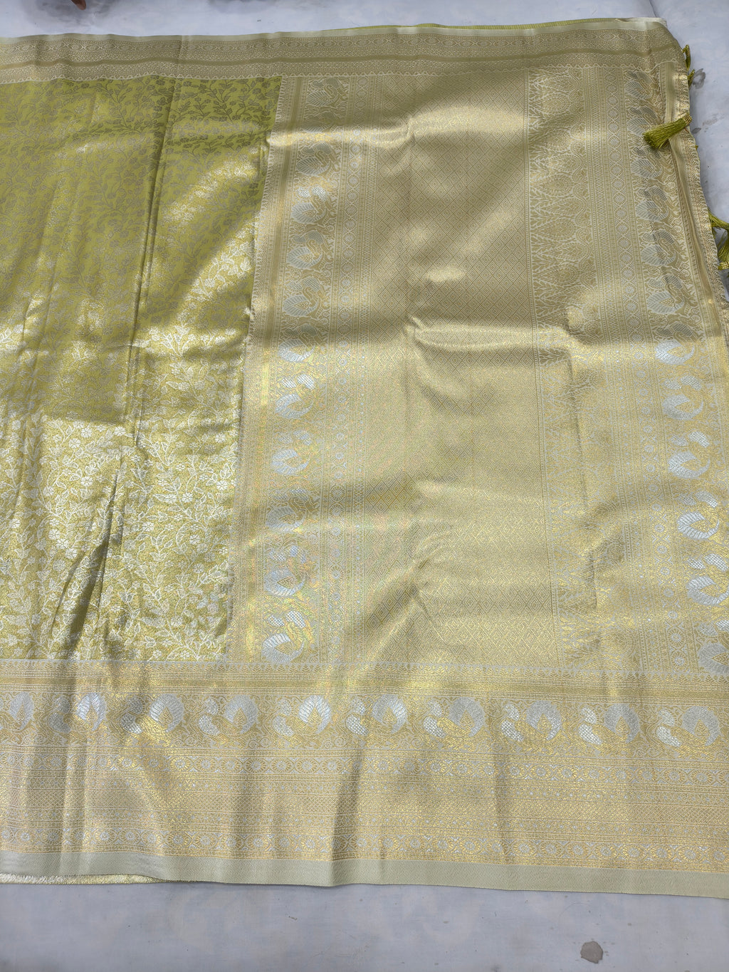 Olive green saree with cream-gold woven motifs and wide zari border