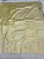 Olive green saree with cream-gold woven motifs and wide zari border