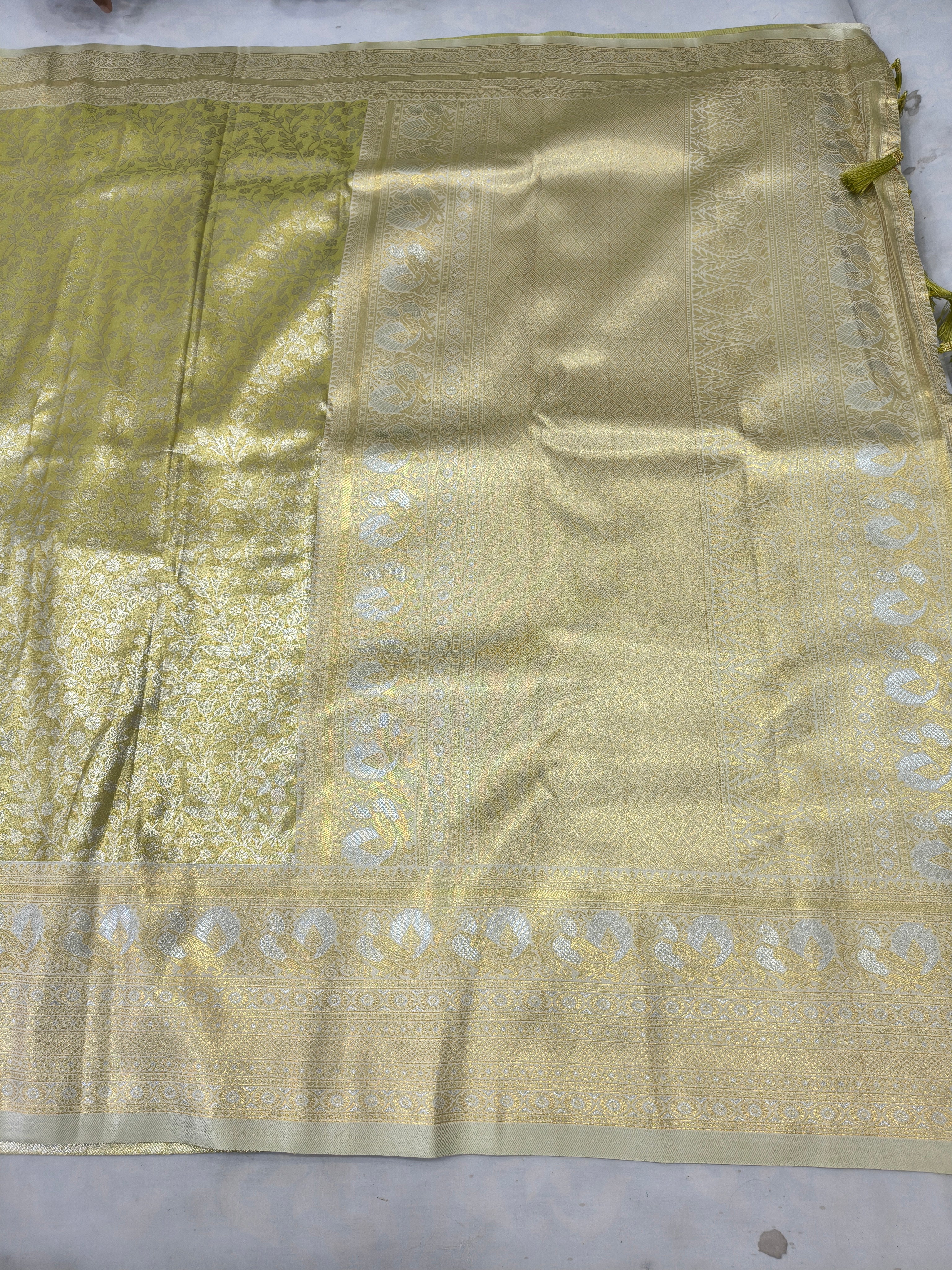 Olive green saree with cream-gold woven motifs and wide zari border