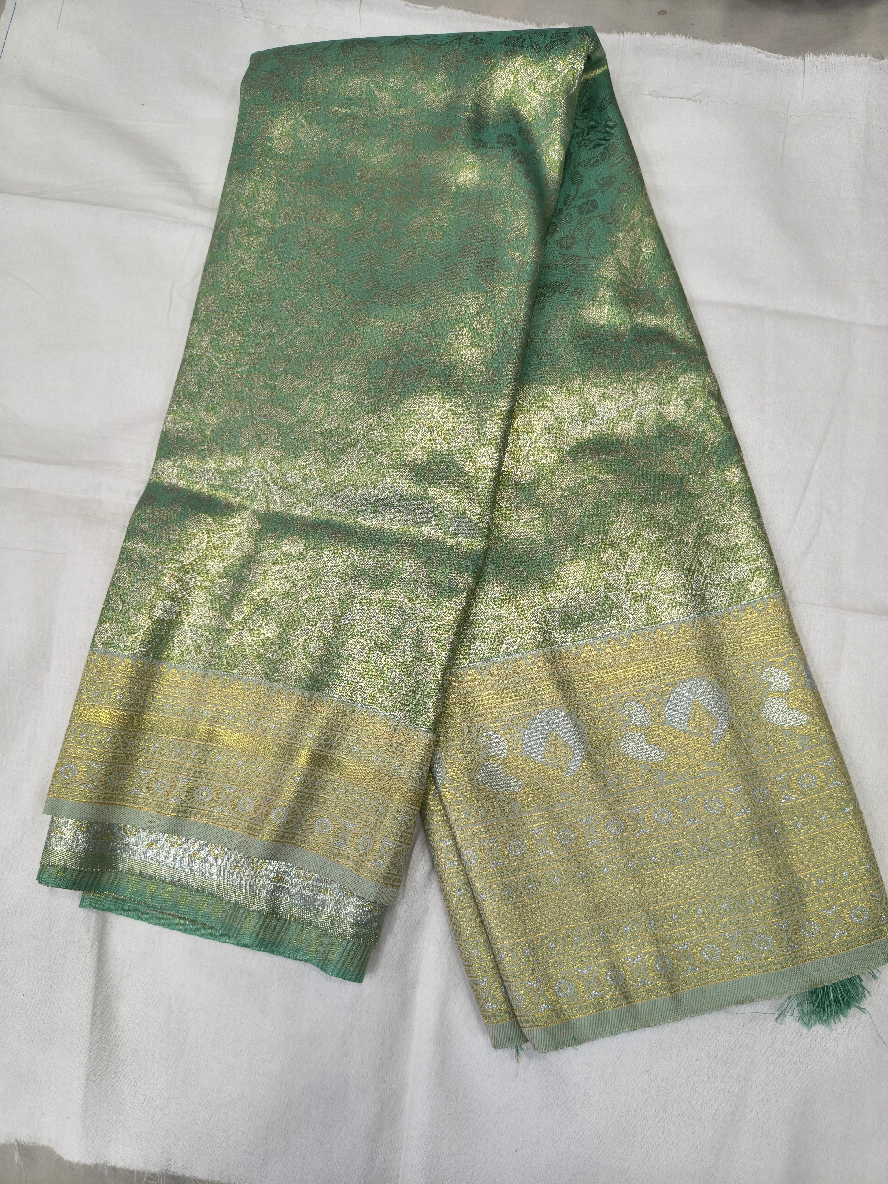 Sea green Banarasi silk saree with beige border, folded view showing woven patterns