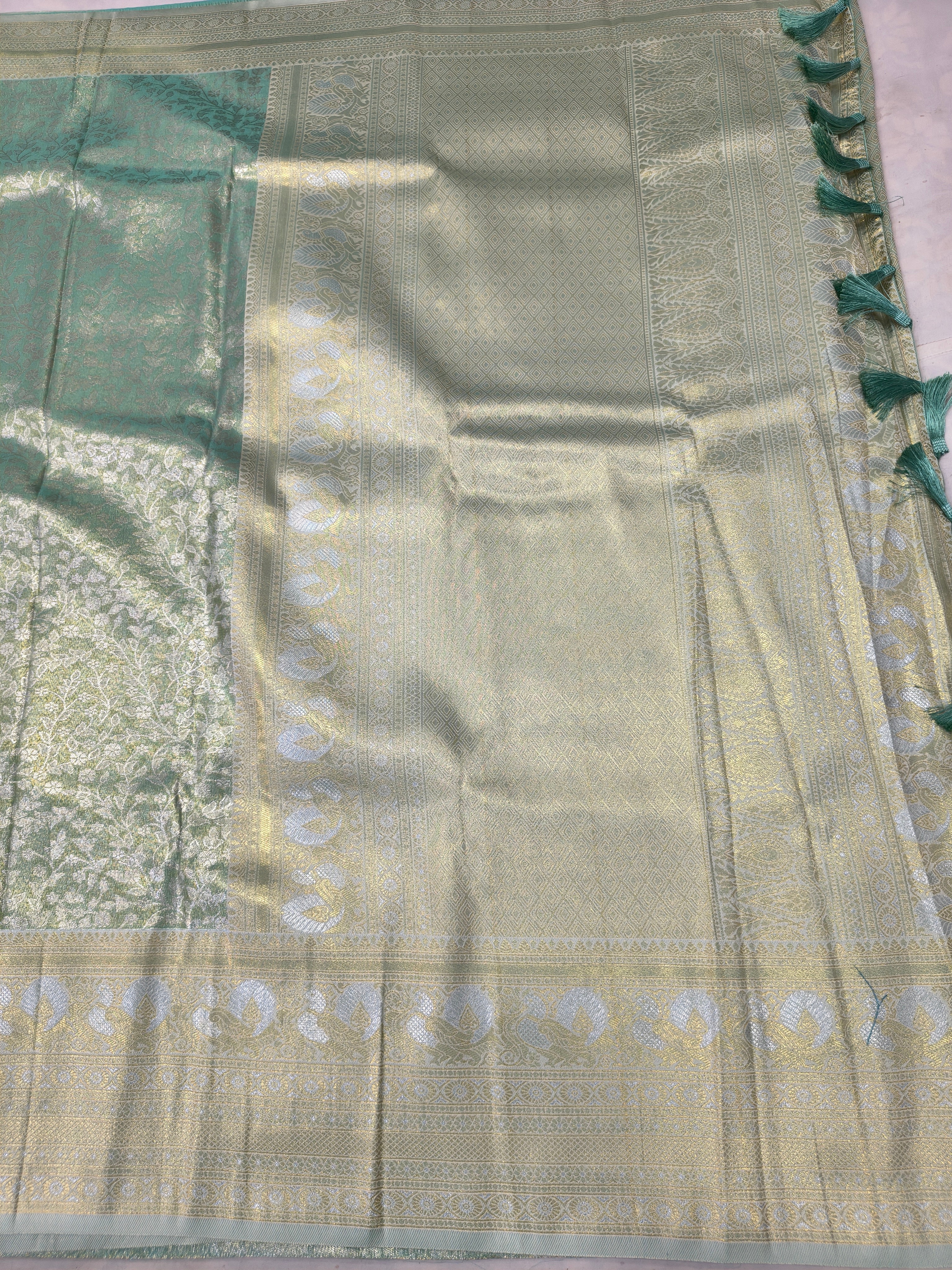 Sea green and beige Banarasi silk saree pallu detail with ornate gold-toned motifs