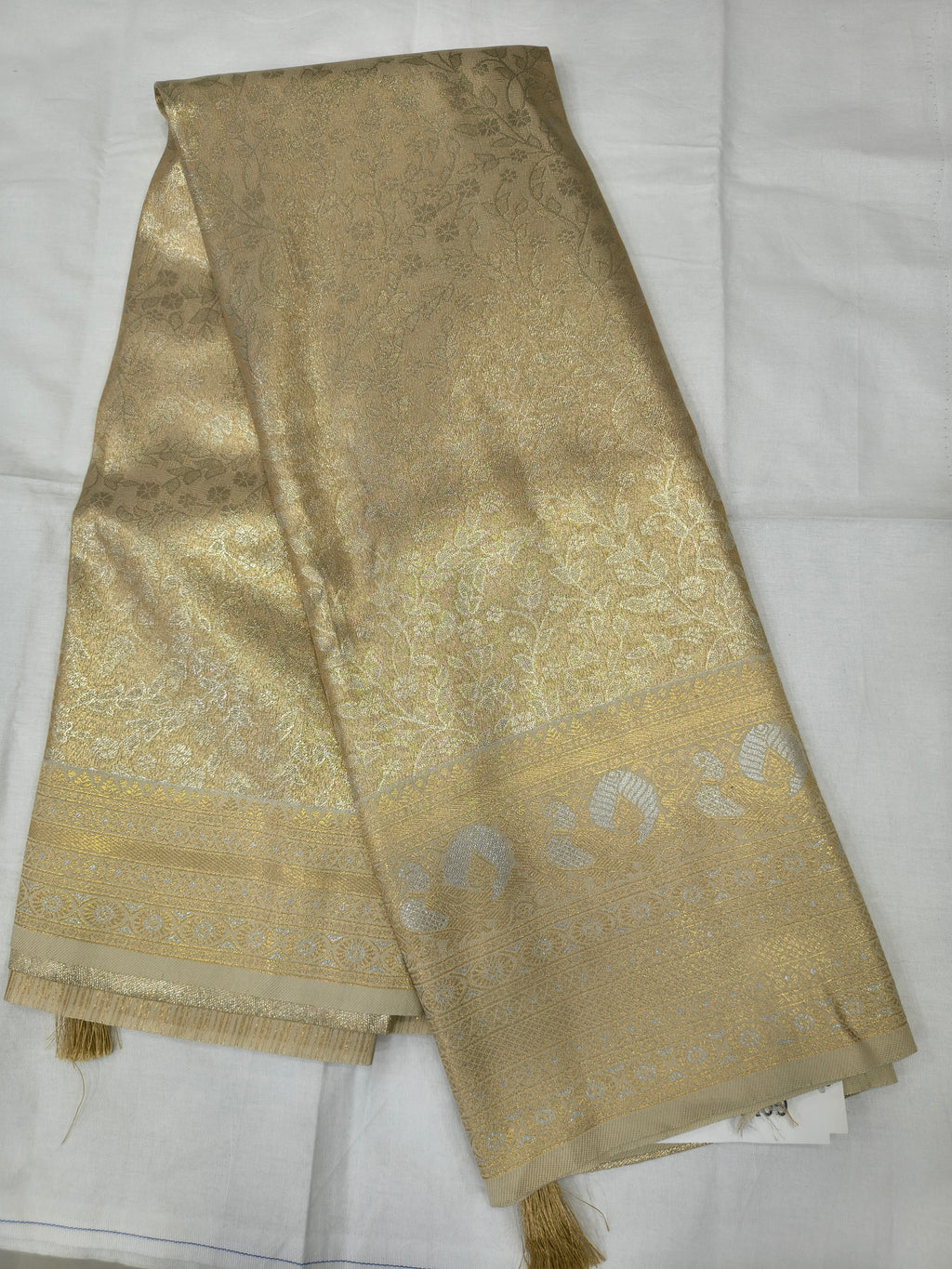 Gold-toned silk fabric set for unstitched blouse with woven motifs and tassels