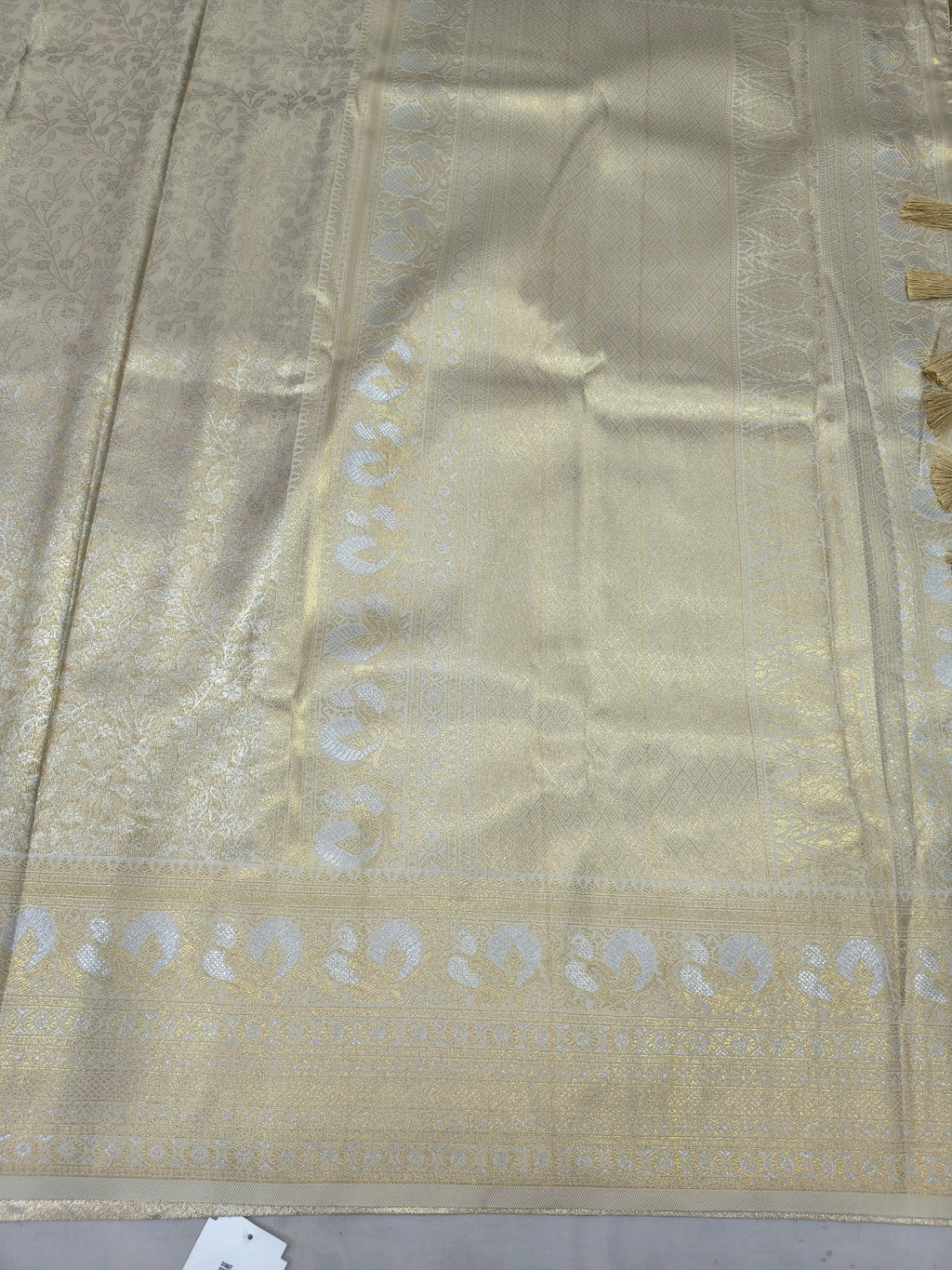 Cream Banarasi silk saree pallu fabric with gold zari motifs and woven border