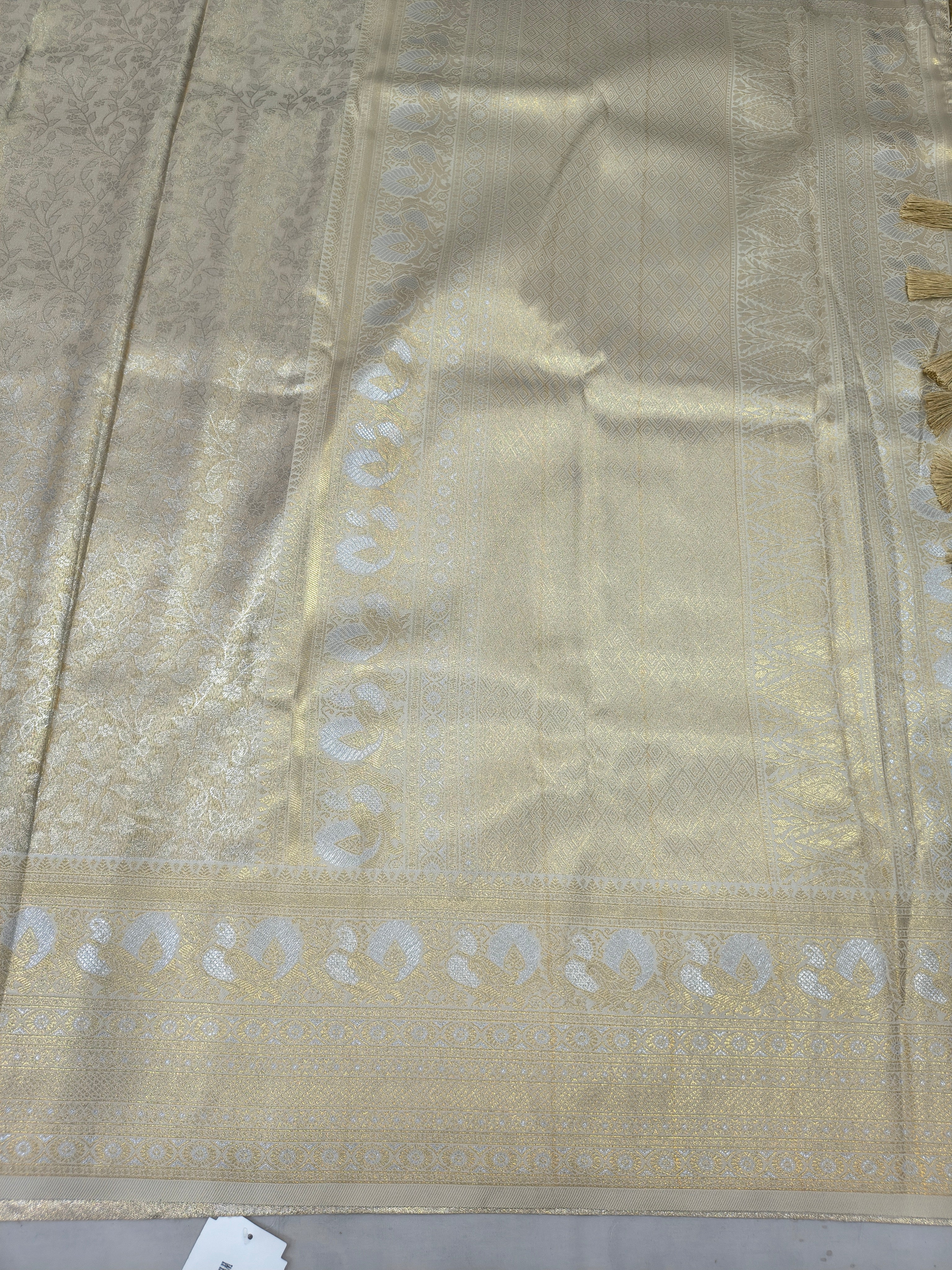 Cream Banarasi silk saree pallu fabric with gold zari motifs and woven border