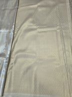 Cream Banarasi silk saree fabric with subtle gold motifs and zari border detail