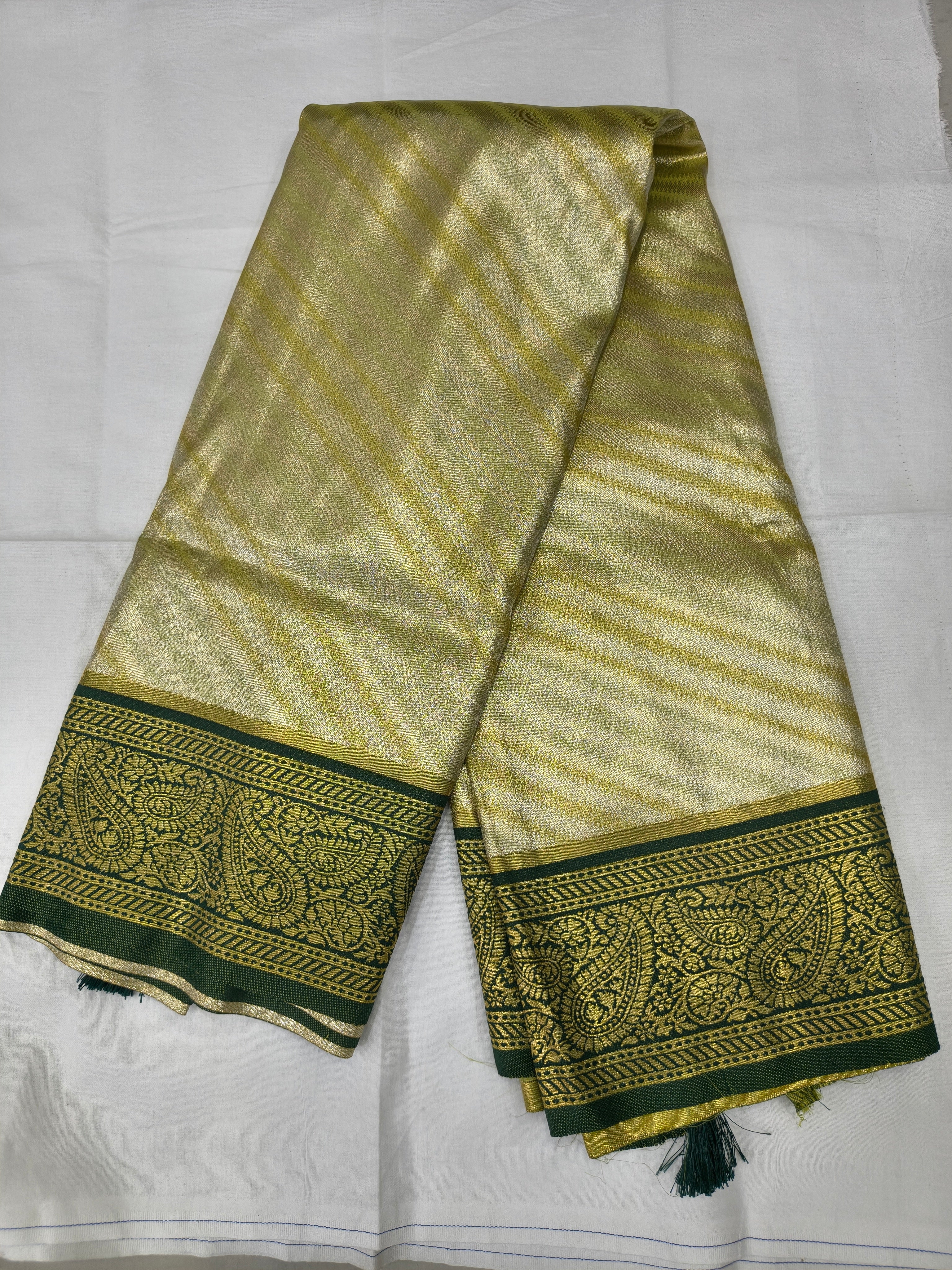 Olive and beige Banarasi silk saree with green patterned border and tassels on pallu