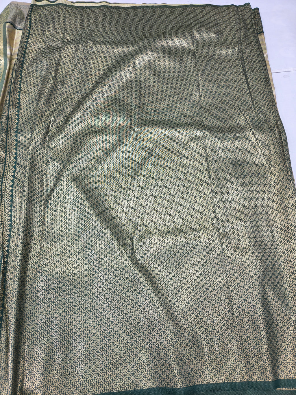Banarasi silk saree fabric with fine olive dots and subtle metallic sheen