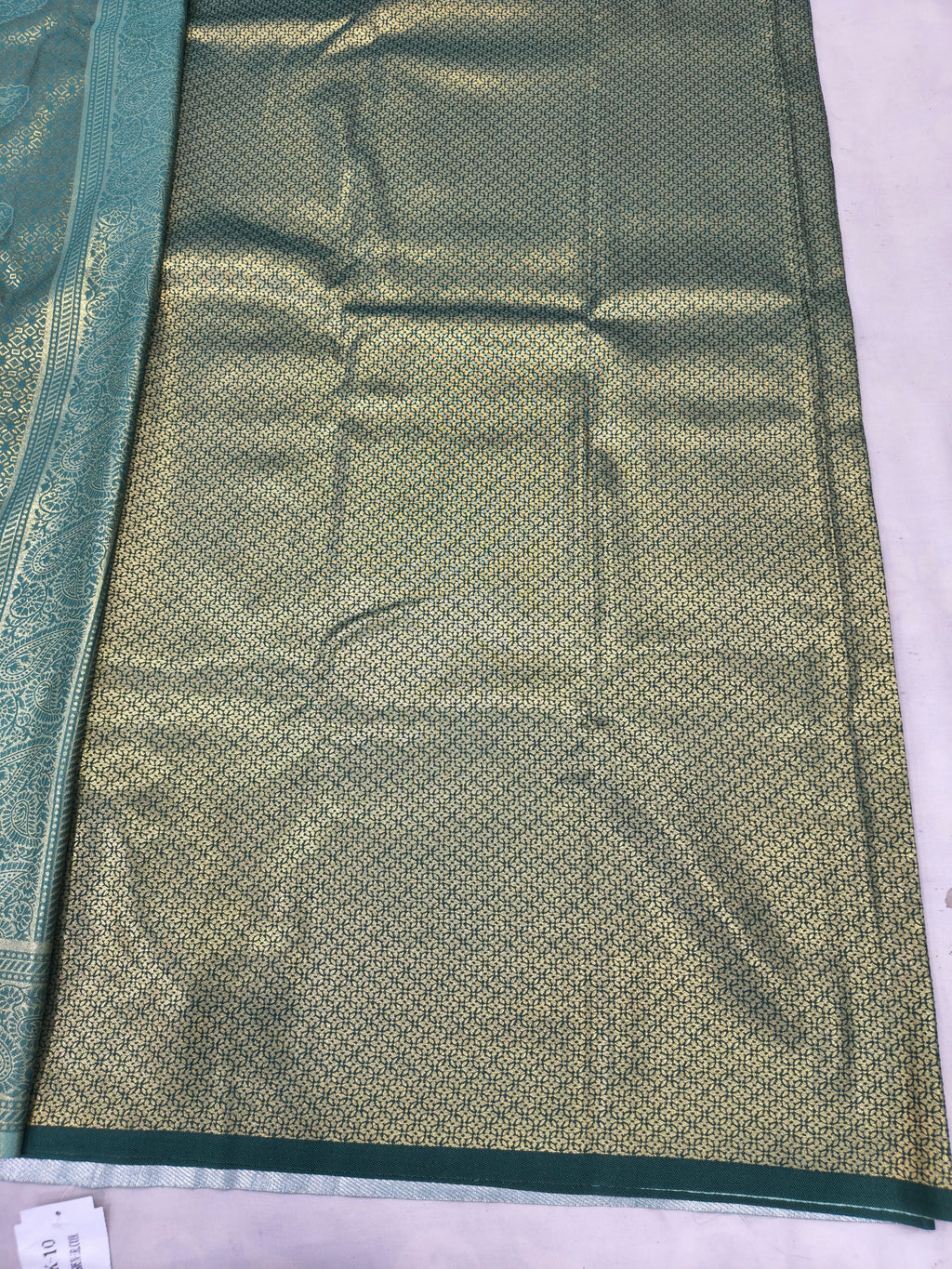 Teal and olive green Banarasi silk saree with textured woven body and inner panel