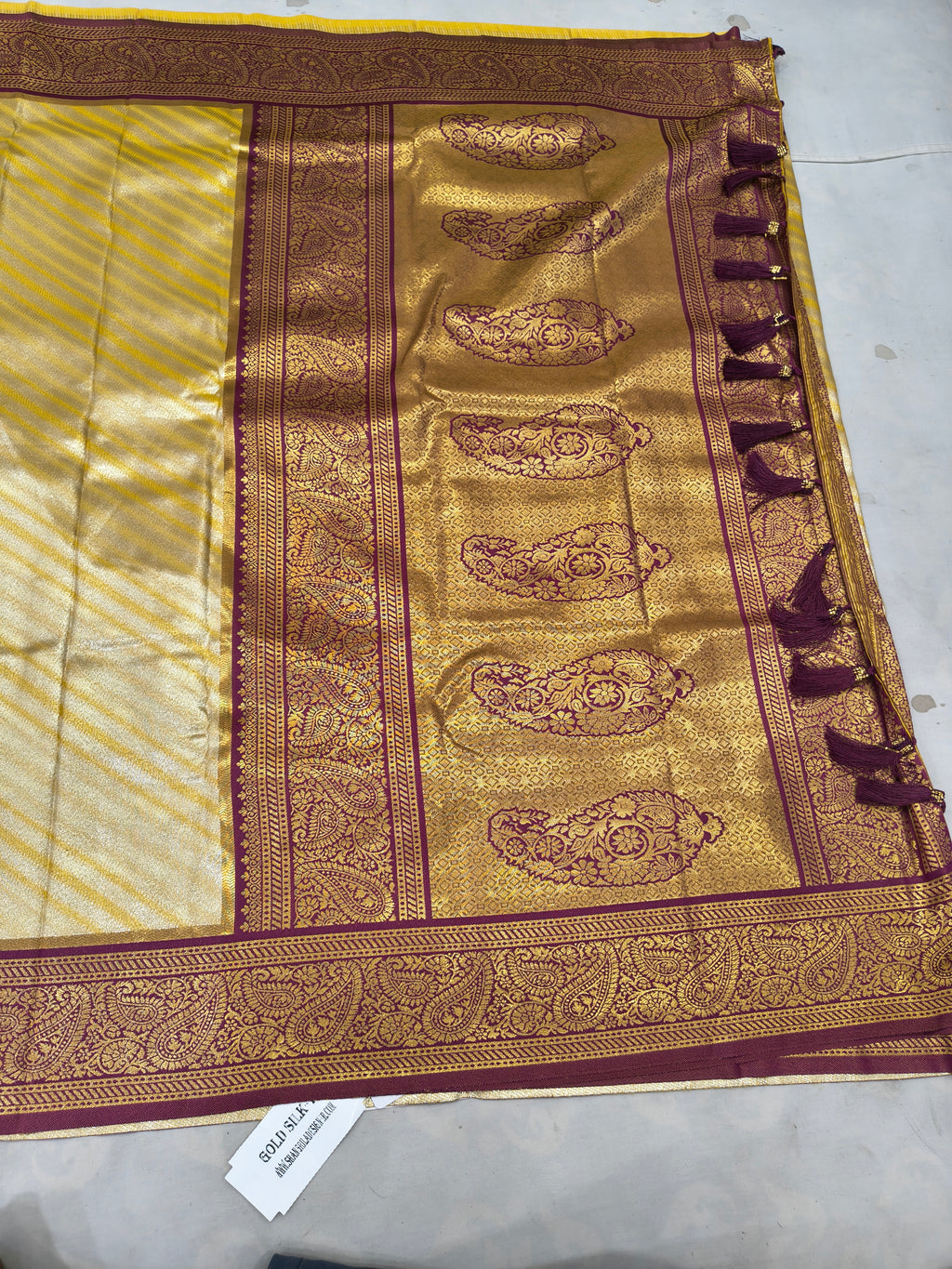 Banarasi silk saree pallu, gold brocade motifs on maroon field with ornate border