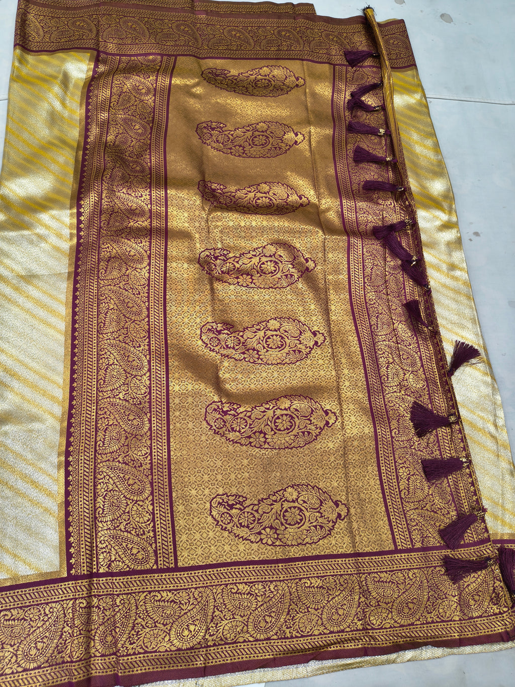 Banarasi silk saree close-up: gold-beige weave with maroon ornamental panel