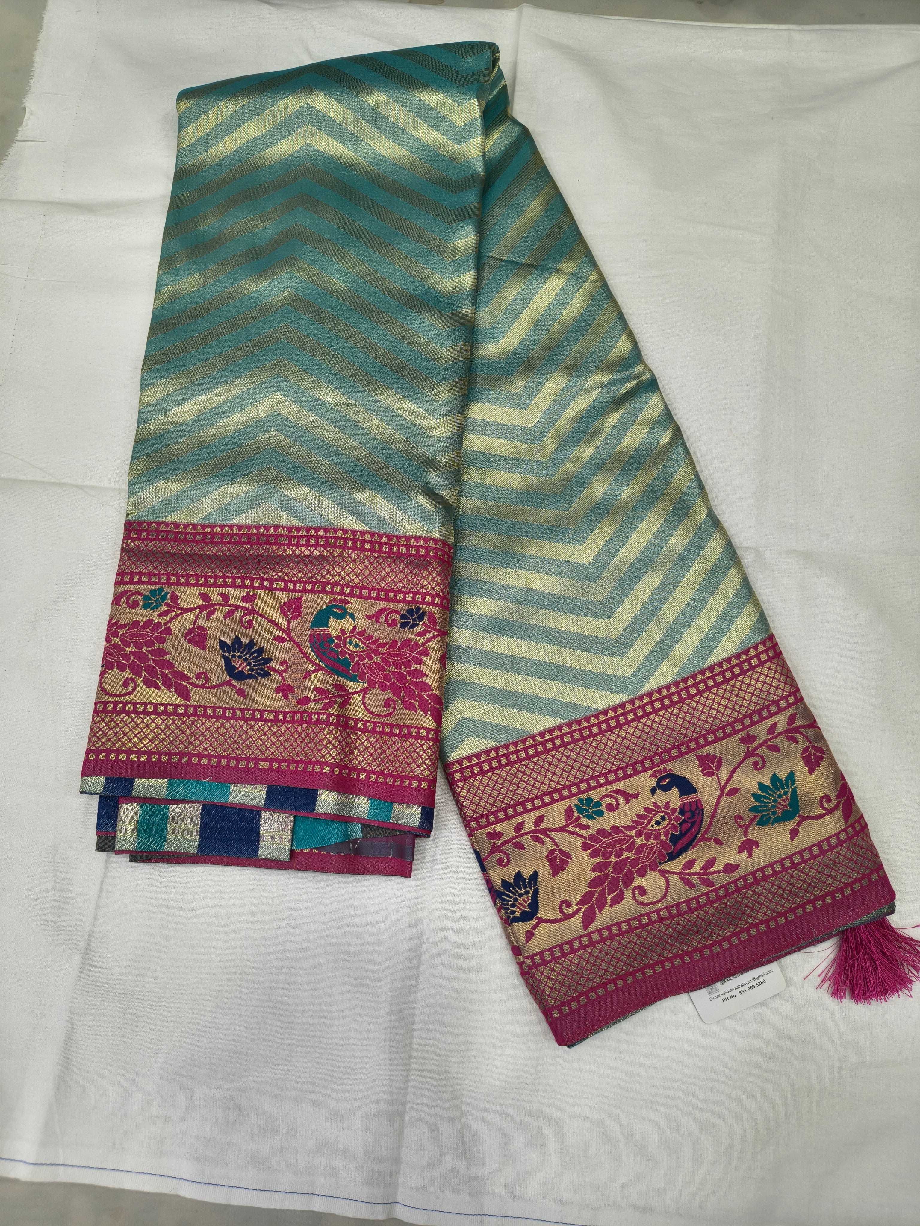 Teal zigzag Banarasi silk saree with magenta border and matching unstitched blouse piece