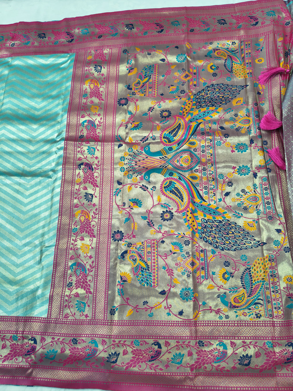 Banarasi silk saree pallu close-up with teal stripes and ornate multicolor motifs