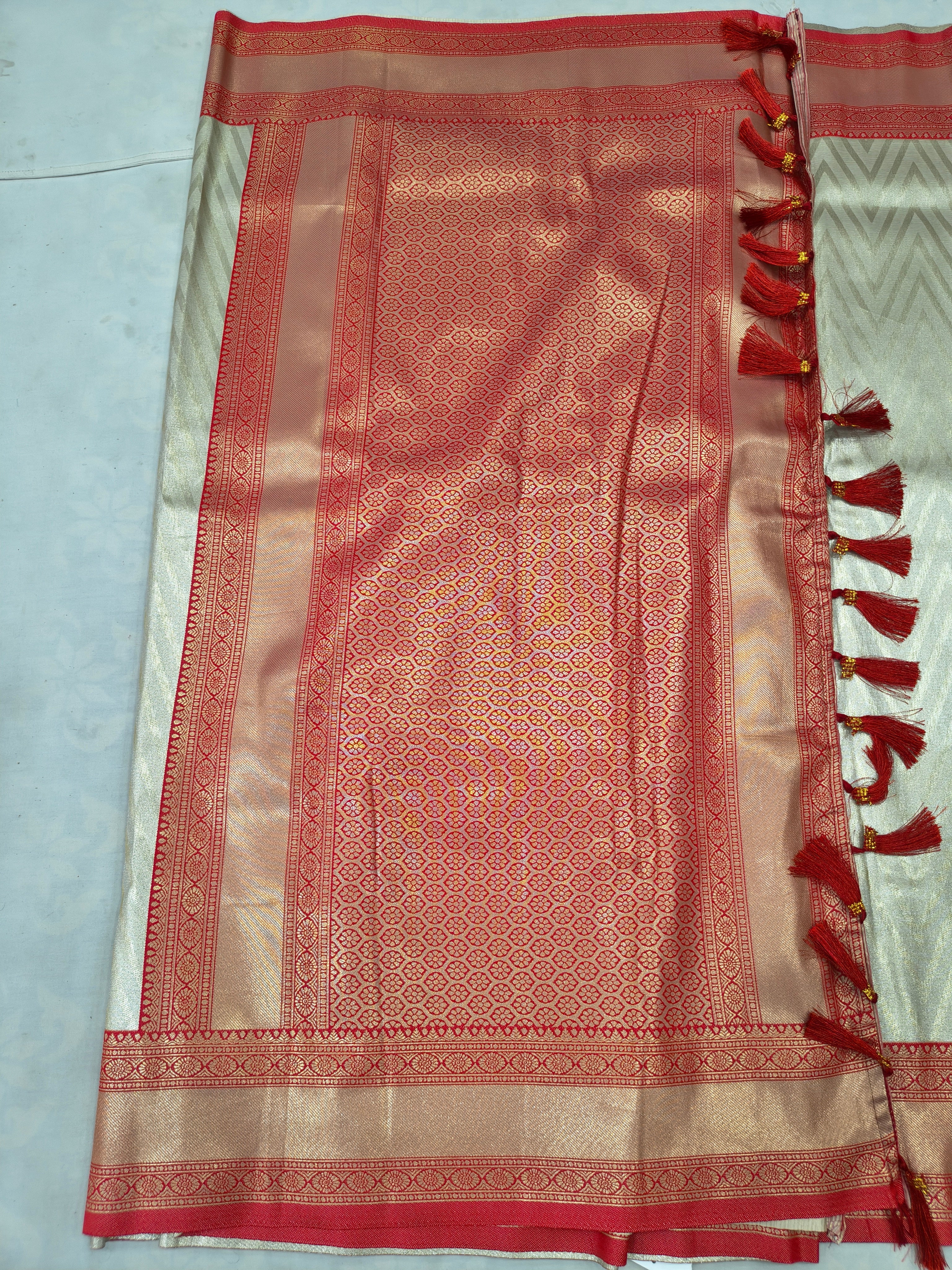 Red Banarasi silk pallu panel with geometric weave, cream border and tassel fringe