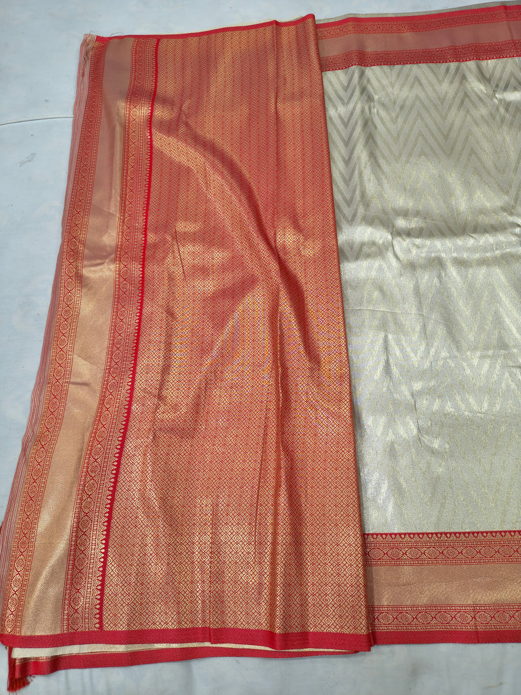 Cream and red Banarasi silk saree fabric with contrast border and textured weave