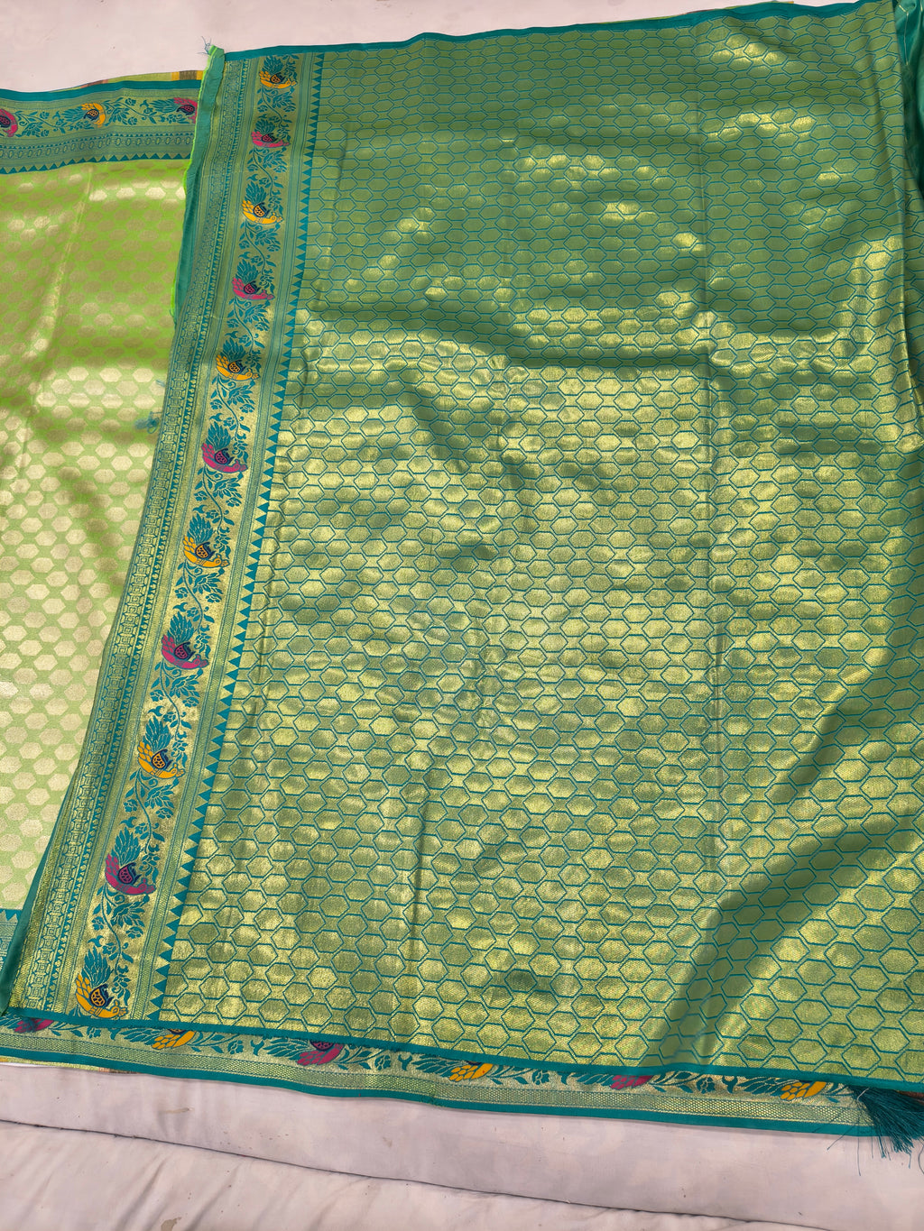 Green Banaras silk saree with textured pattern and blue border