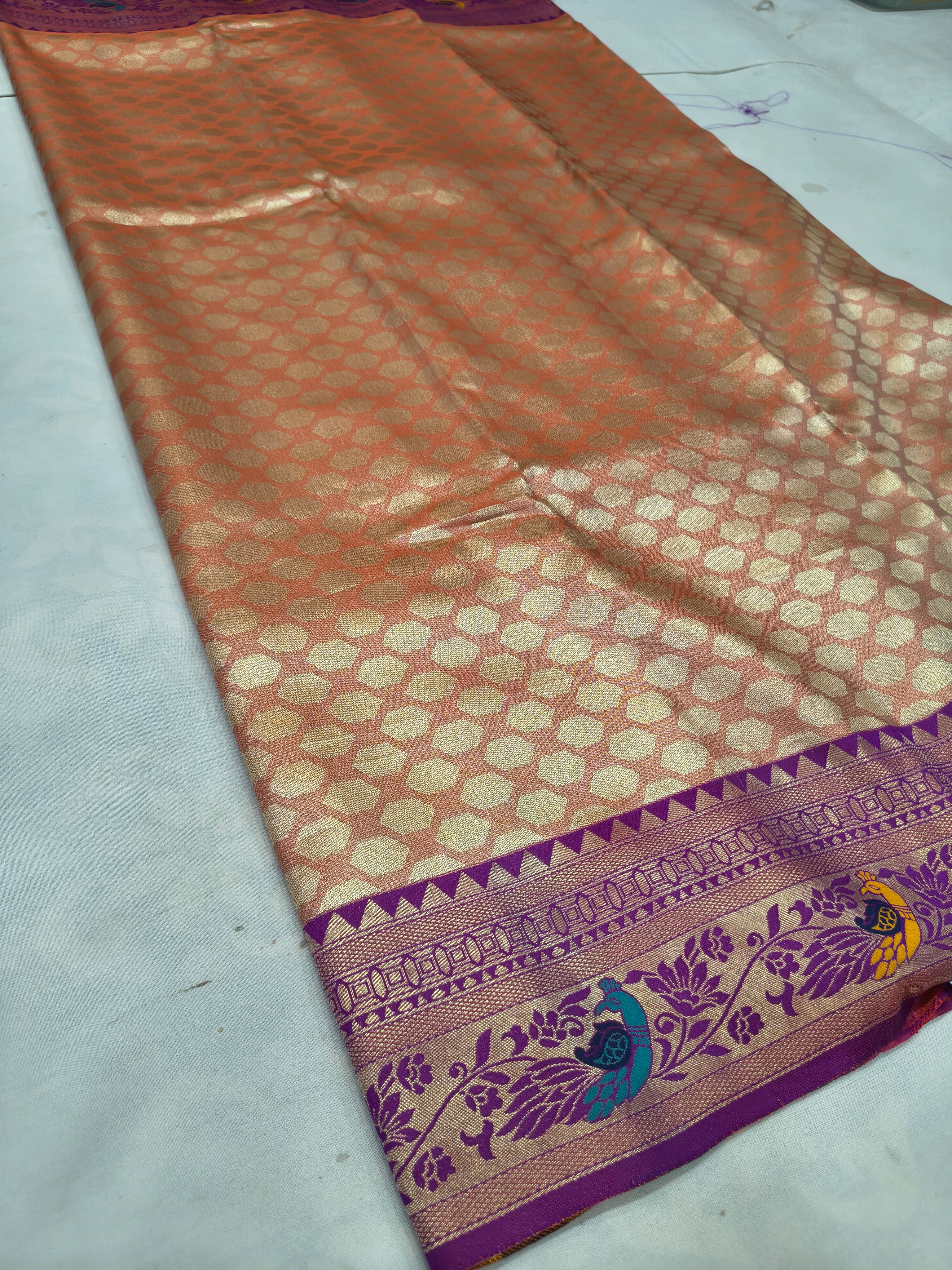 Banarasi silk saree pleat with orange-brown geometric pattern and purple zari border