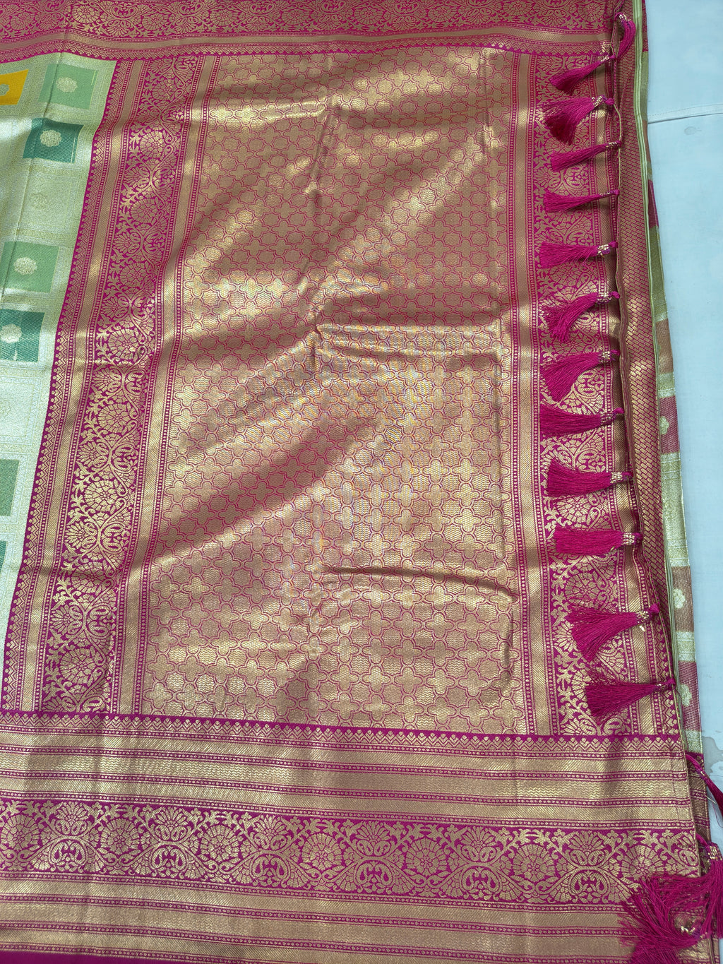 Silk saree pallu with pink-gold woven panel, teal border stripe, fringe edge