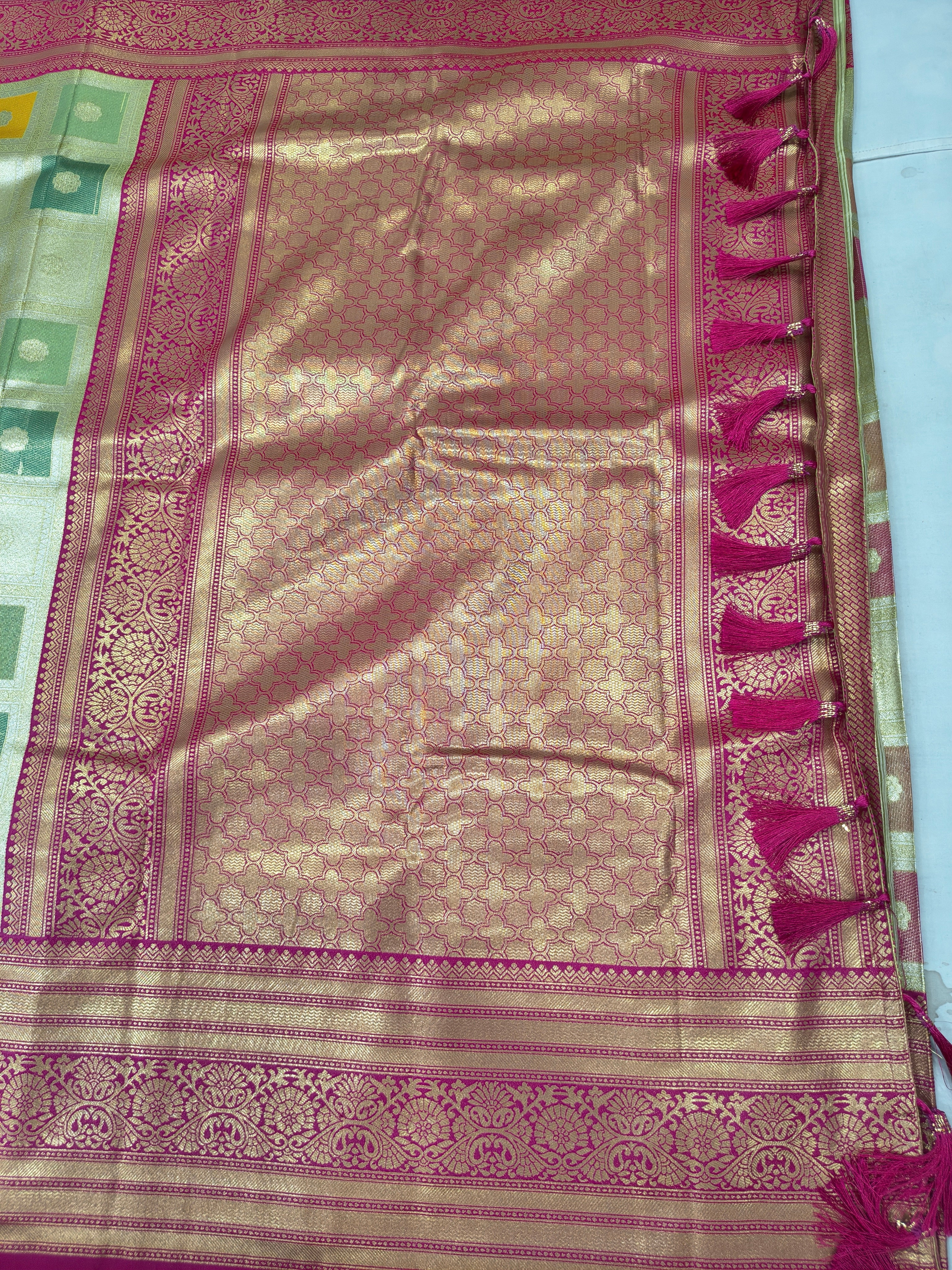 Silk saree pallu with pink-gold woven panel, teal border stripe, fringe edge